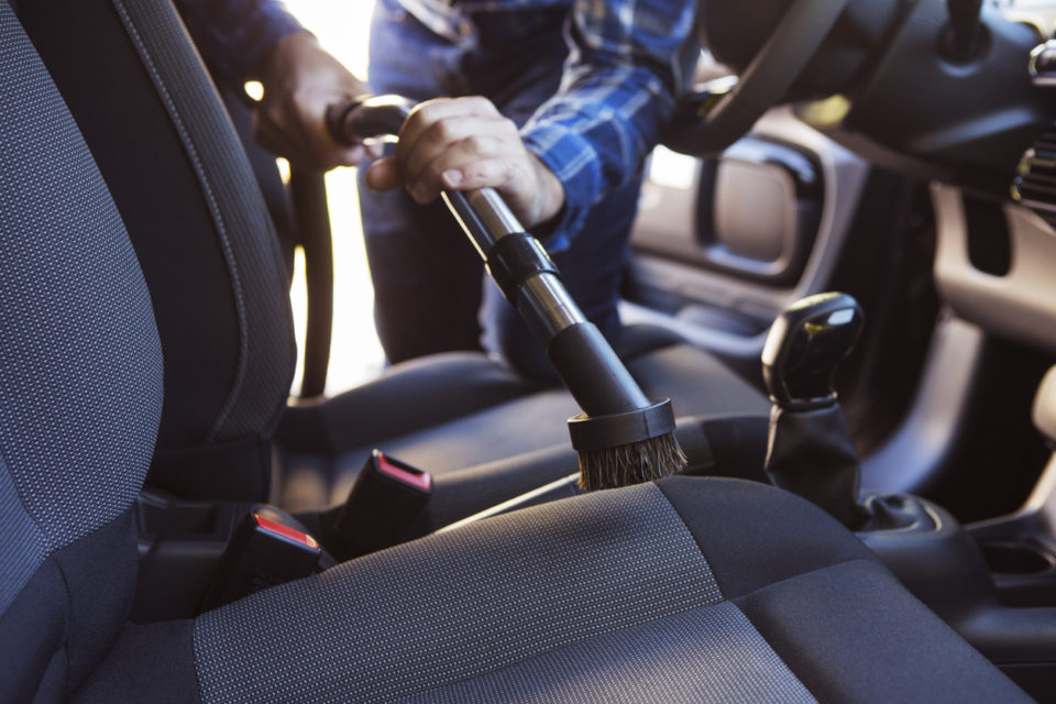 Man Vacuuming Seat Of Car During Car Cleaning