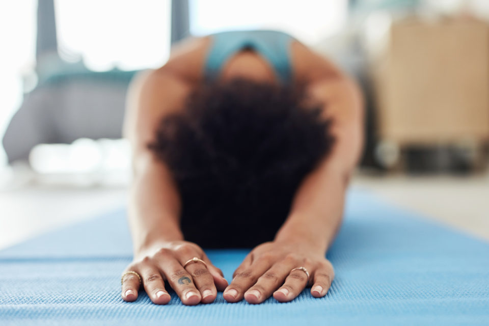 Shot of a fit young woman doing yoga at home