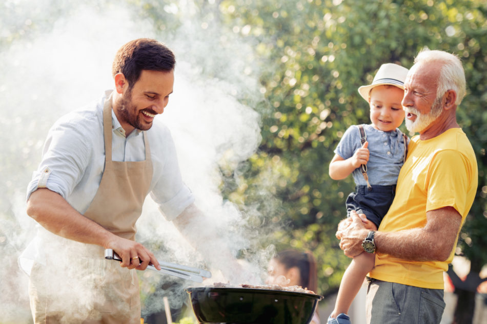 Happy family having barbecue party at summer garden