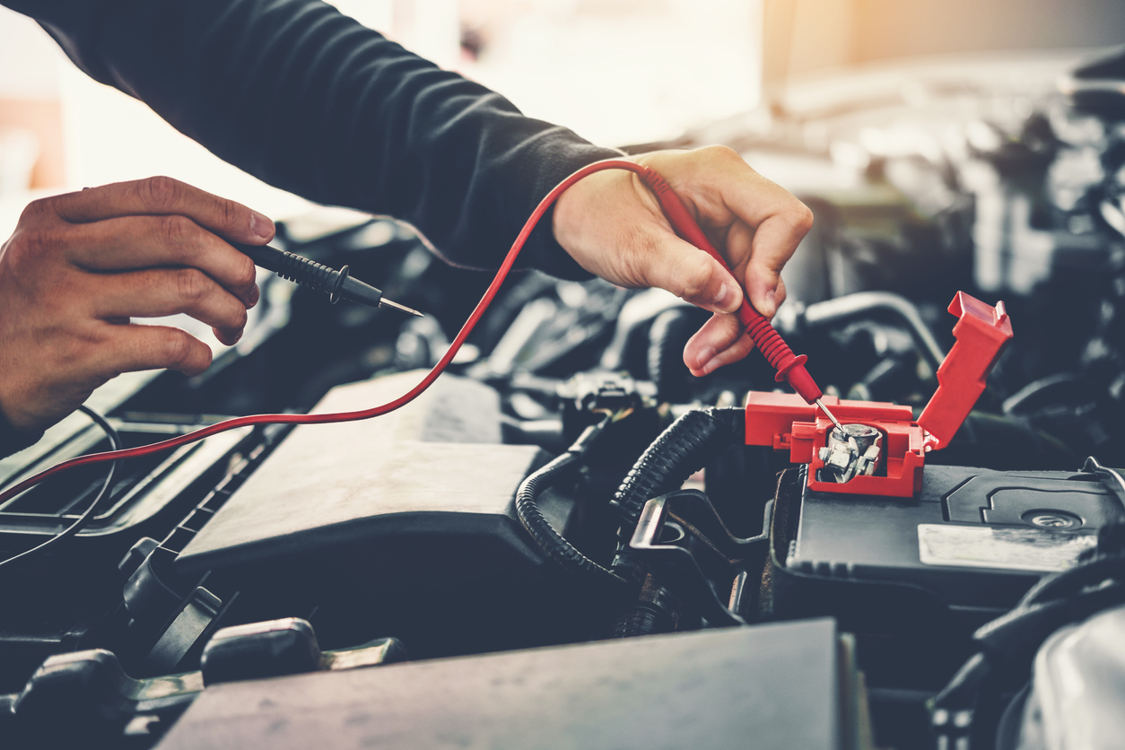 technician checks car battery 