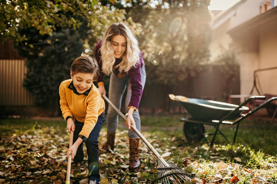 Mother and son playing in backyard with gardening equipment
