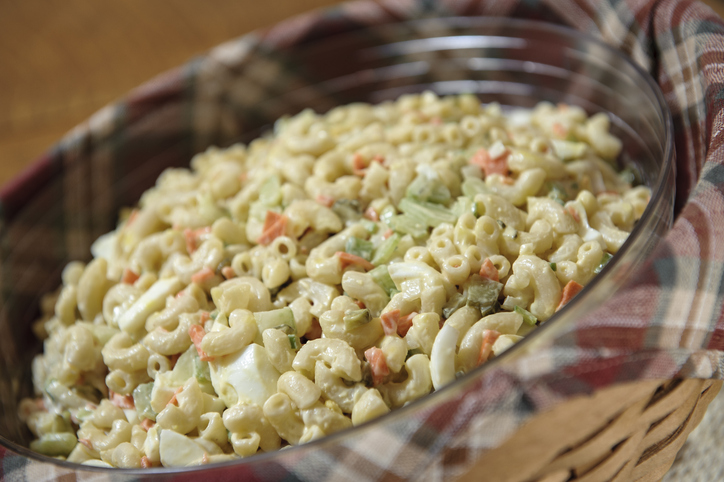 A bowl of fresh macaroni salad in a wicker basket.