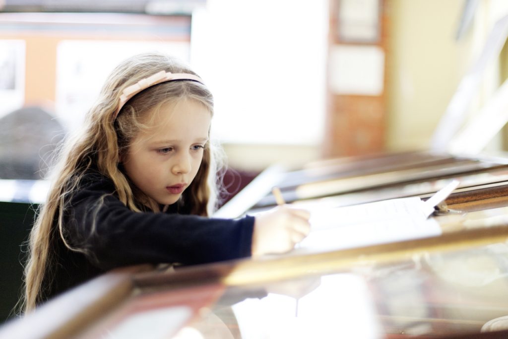 Child by a museum display cabinet