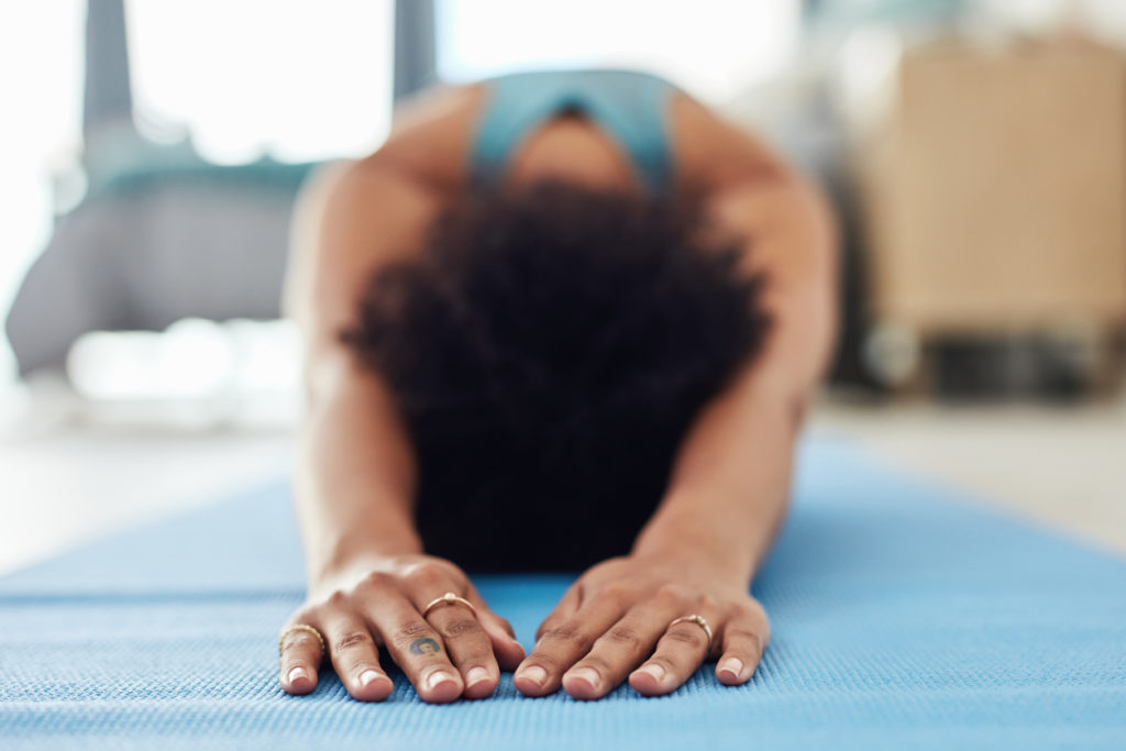 Shot of a fit young woman doing yoga at home