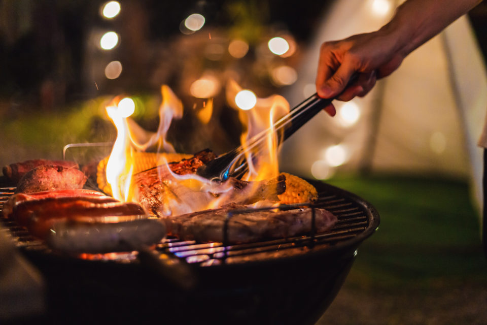 flames rising from grill at night