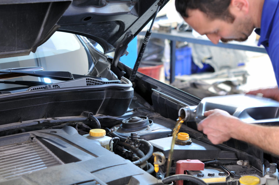 Mechanic changing oil in vehicle