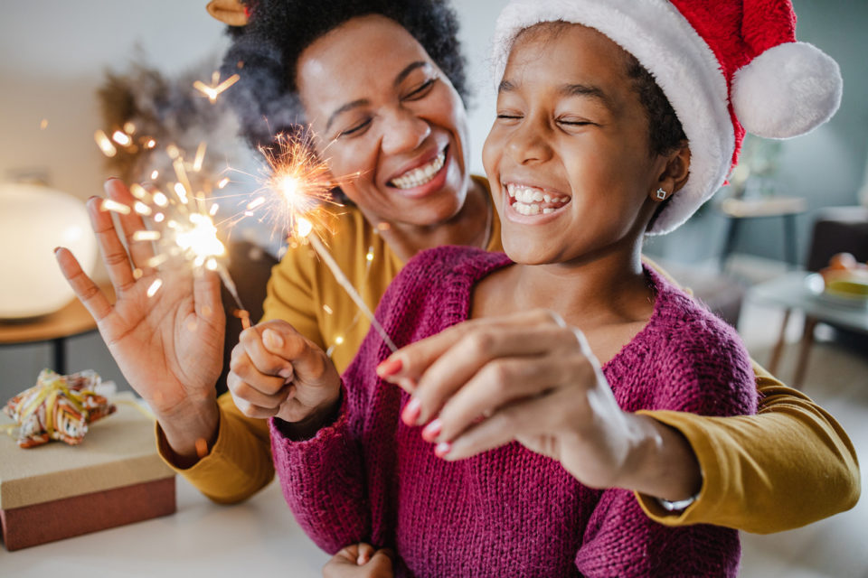 Portrait of a mother and daughter holding New Year's sparklers at home